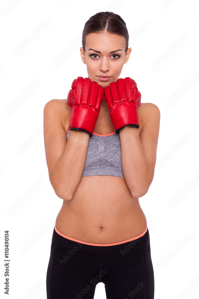 Strong and beautiful. Beautiful young sporty woman in boxing gloves looking at camera while standing against white background Strong and beautiful. Beautiful young sporty woman in boxing gloves looking at camera while standing against white background
