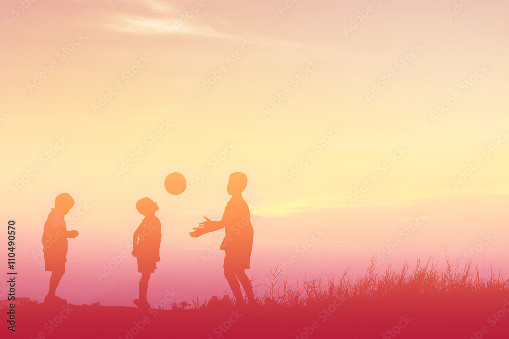 boys playing football at sunset. silhouette concept