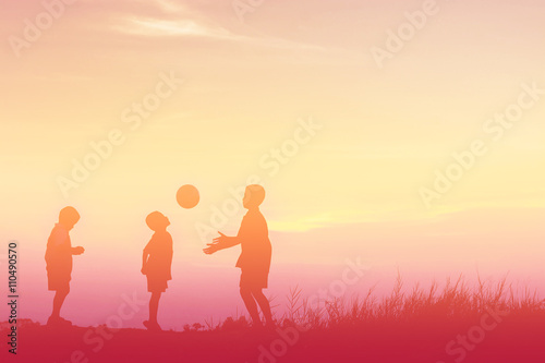 boys playing football at sunset. silhouette concept © Johnstocker