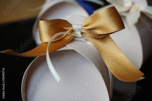 Small papery gift box with a golden ribbon on the top  © martinprague