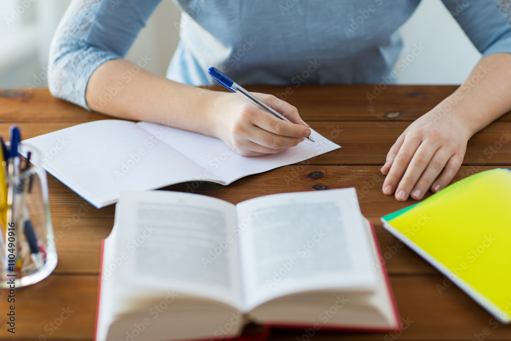 close up of student with book and notebook at home close up of student with book and notebook at home