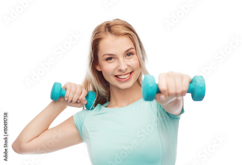 smiling beautiful young sporty woman with dumbbell