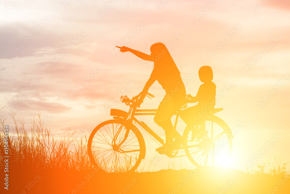 Silhouette of mother and daughter biking at sunset happy time Silhouette of mother and daughter biking at sunset happy time