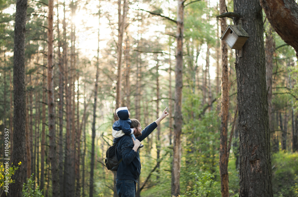 Father with baby son walking in forest Father with baby son walking in forest
