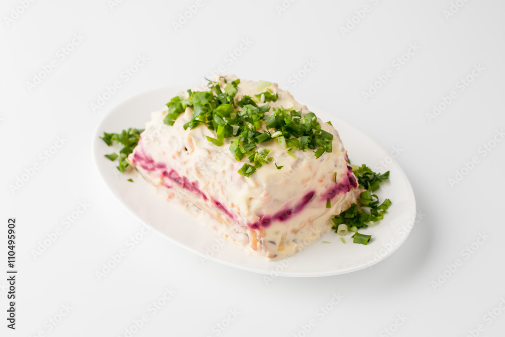 Herring under beetroot and mayonnaise in a white ceramic plate Herring under beetroot and mayonnaise in a white ceramic plate