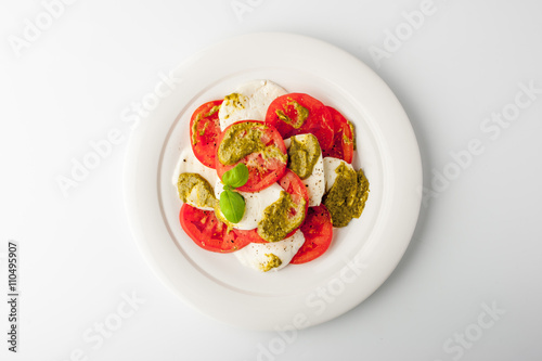 Caprese salad on a ceramic plate on a white table