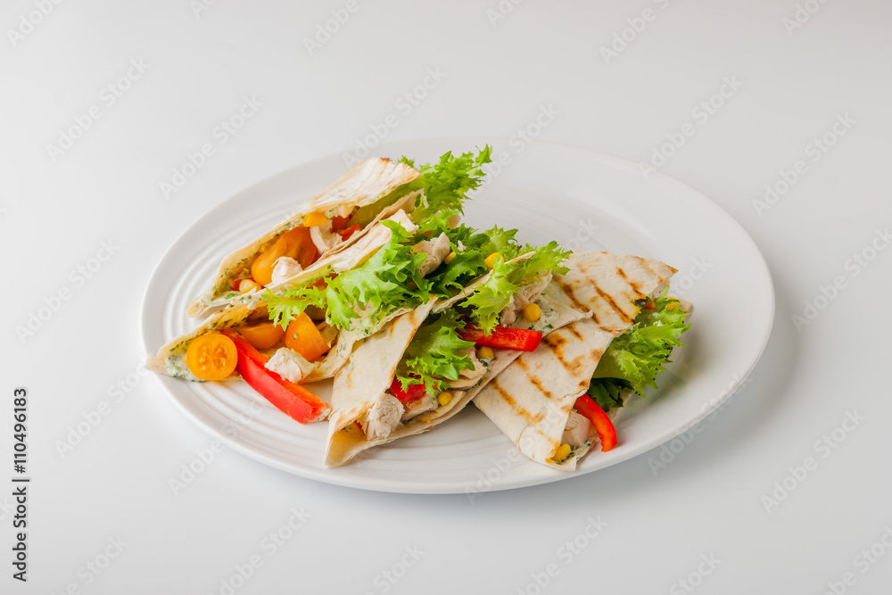 Quesadilla with chicken and corn on a round plate and white bac Quesadilla with chicken and corn on a round plate and white bac
