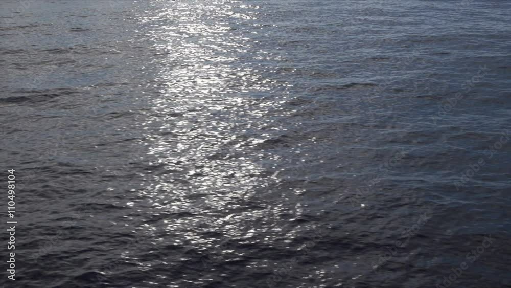 sun reflecting and glinting off waves ripples across water sun reflecting and glinting off waves ripples across water
