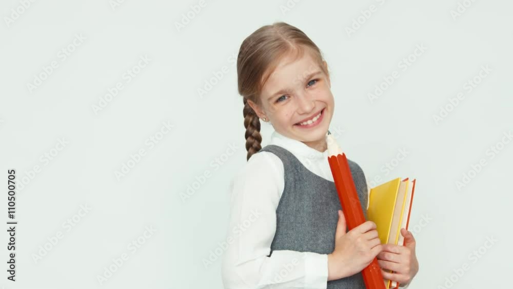 Portrait cute happy schoolgirl child 7-8 years on white background turns around at camera and smiling Portrait cute happy schoolgirl child 7-8 years on white background turns around at camera and smiling