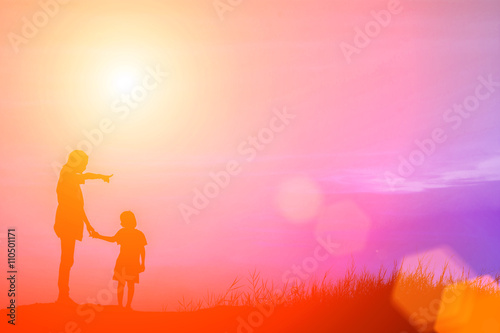 Mother encouraged her son outdoors at sunset, silhouette concept © Johnstocker