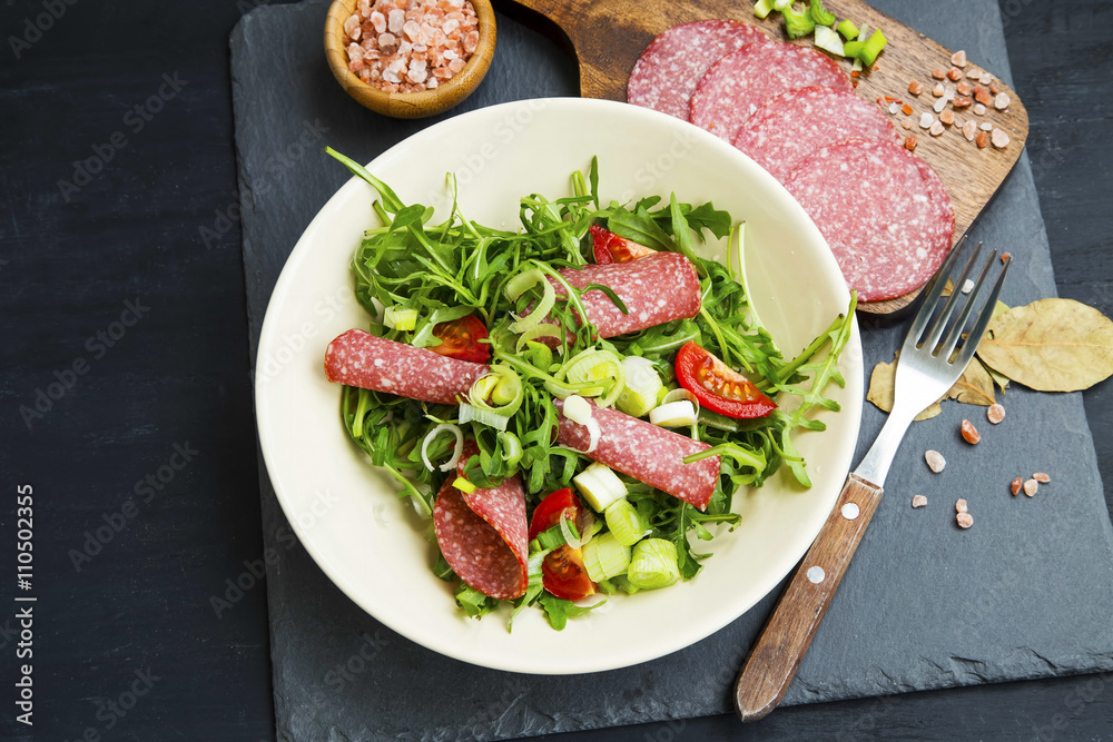 Arugula with salami salad with onions and tomatoes Arugula with salami salad with onions and tomatoes