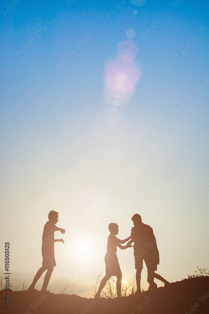 Silhouette of children playing in the park sunset time