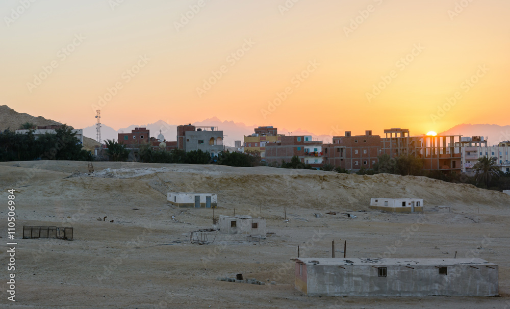 city on the edge of the desert during the evening twilight