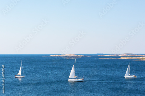 Havs vy över klippig skärgård med segelbåtar