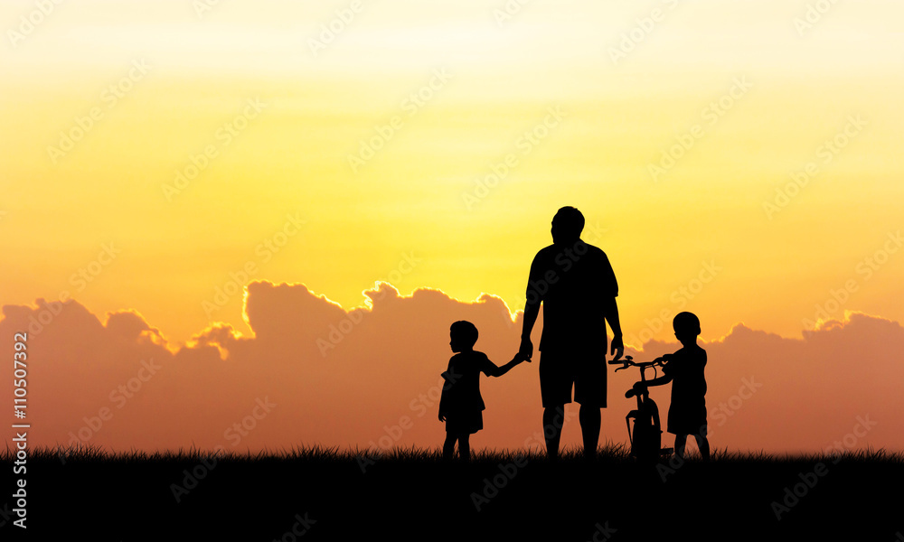 Silhouette of father and boy standing  sunset background