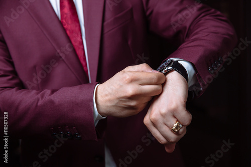 Elegant businessman correcting his cclocks and sleeve. Mans acce