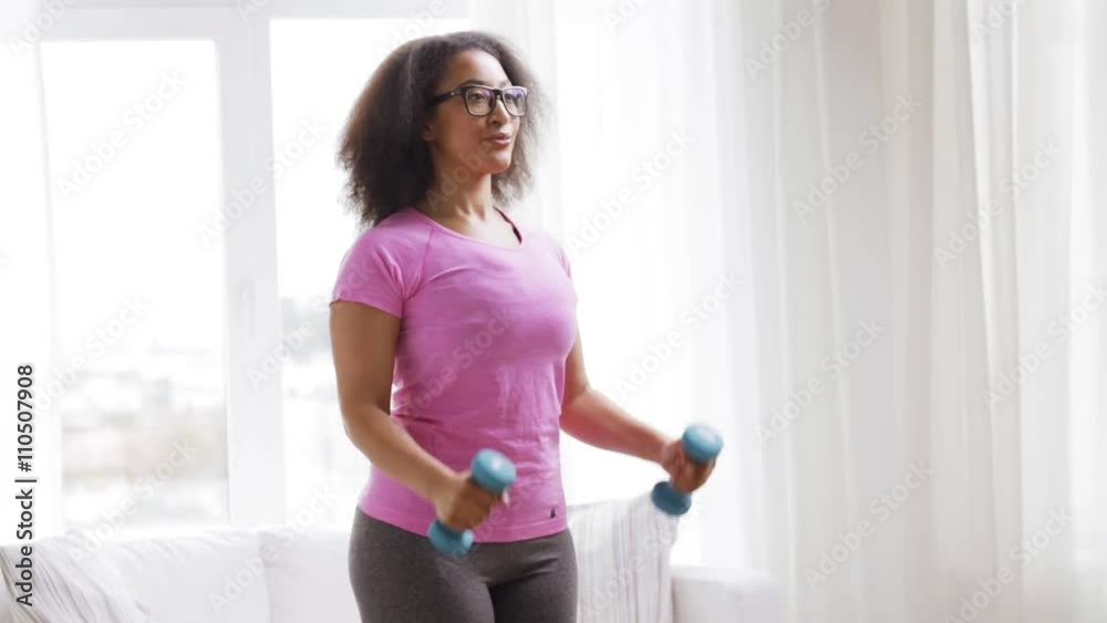 african woman exercising with dumbbells at home african woman exercising with dumbbells at home