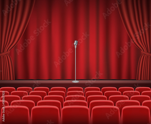Rows of red cinema or theater seats in front of show stage with retro microphone