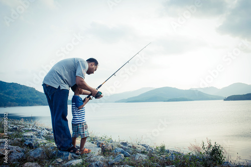 son and dad fishing at dam,vintage tone photo