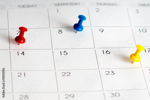 red blue yellow pins on calendar grid