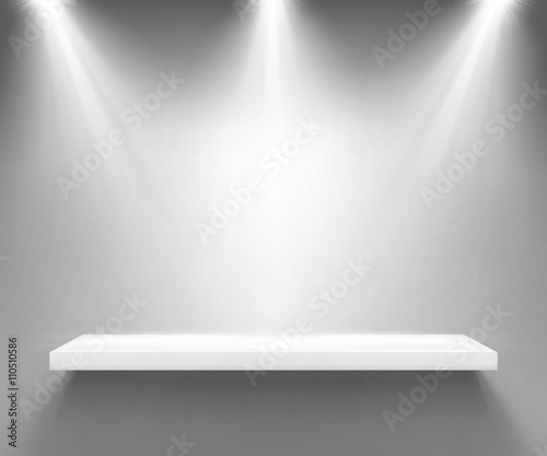 Empty white shelf illuminated by three spotlights