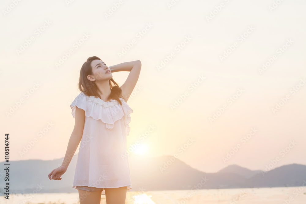 beautiful young woman standing look at the sky nearing seaside i
