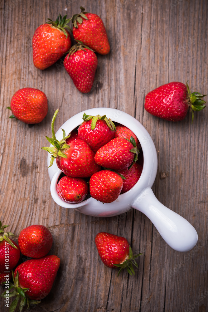 red organic strawberries in white bowl 