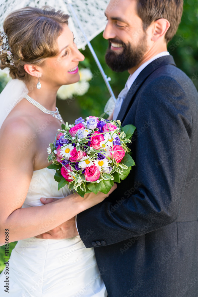 Bridal couple embracing each other in summer garden Bridal couple embracing each other in summer garden