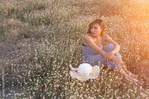 Sexy Beautiful woman sitting in flower field sadly and lonelines photo