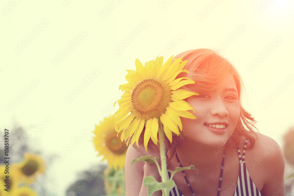 Beautiful sexy woman with sunflower in sunflower fields smile at