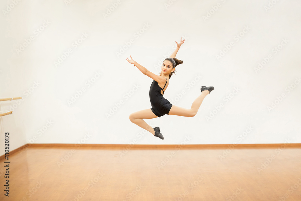 Fototapeta premium Girl practicing some jumps in dance class