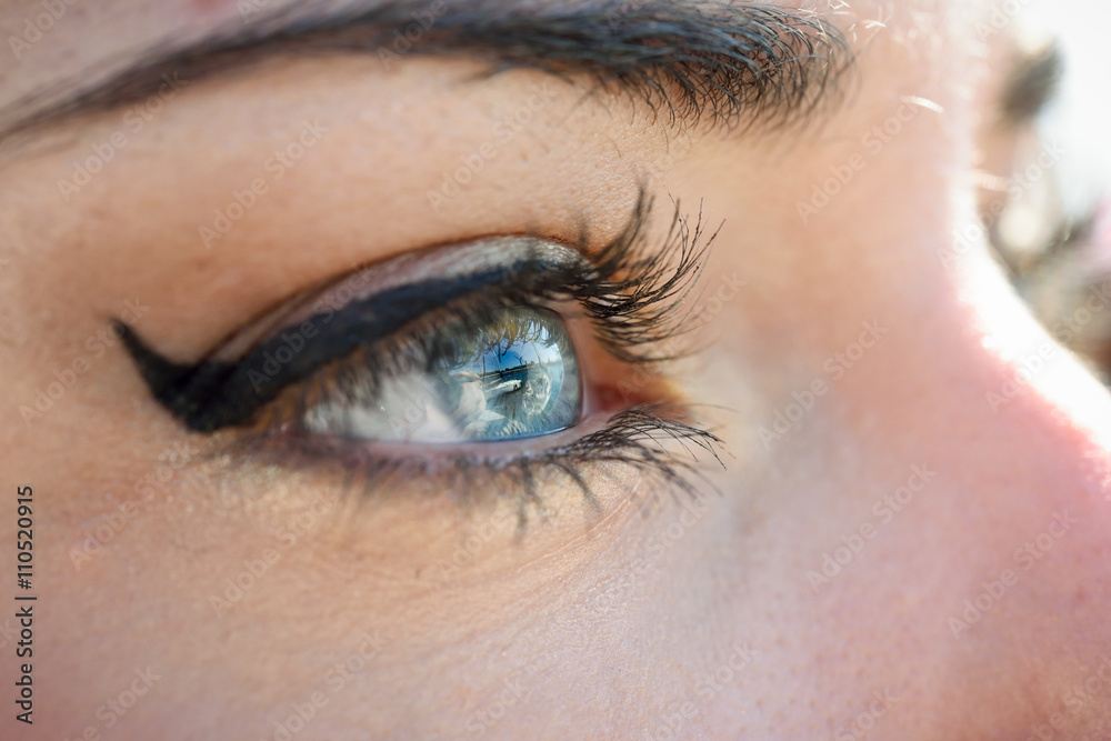 Fototapeta premium Close-up of young woman's blue eyes with long eyelashes