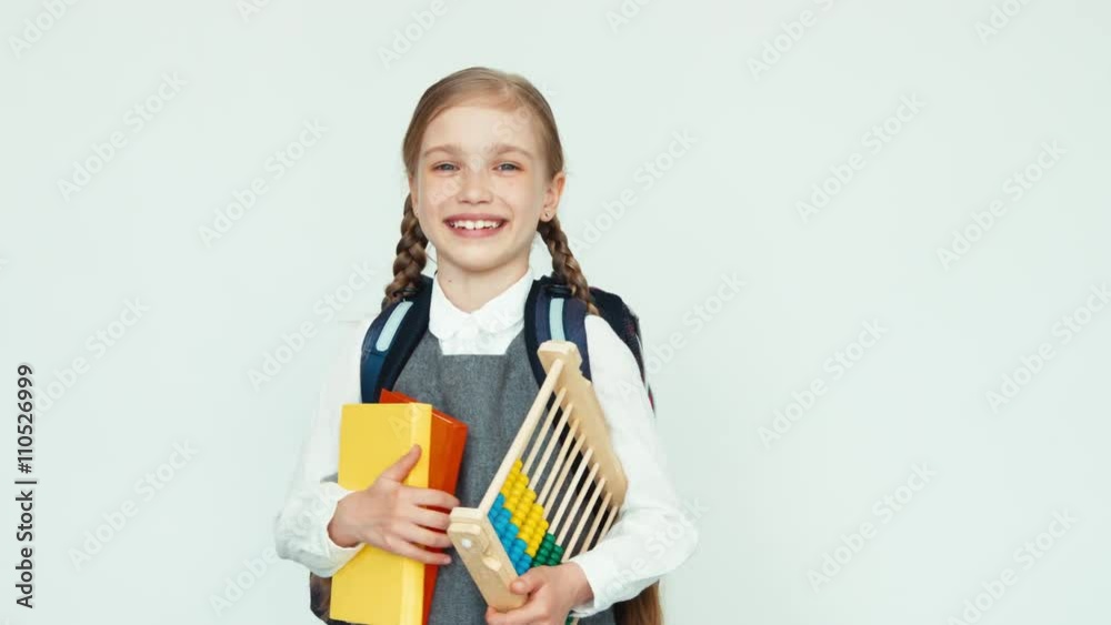 Portrait cute schoolgirl child 7-8 years with backpack holding abacus and books on white background laughing Portrait cute schoolgirl child 7-8 years with backpack holding abacus and books on white background laughing