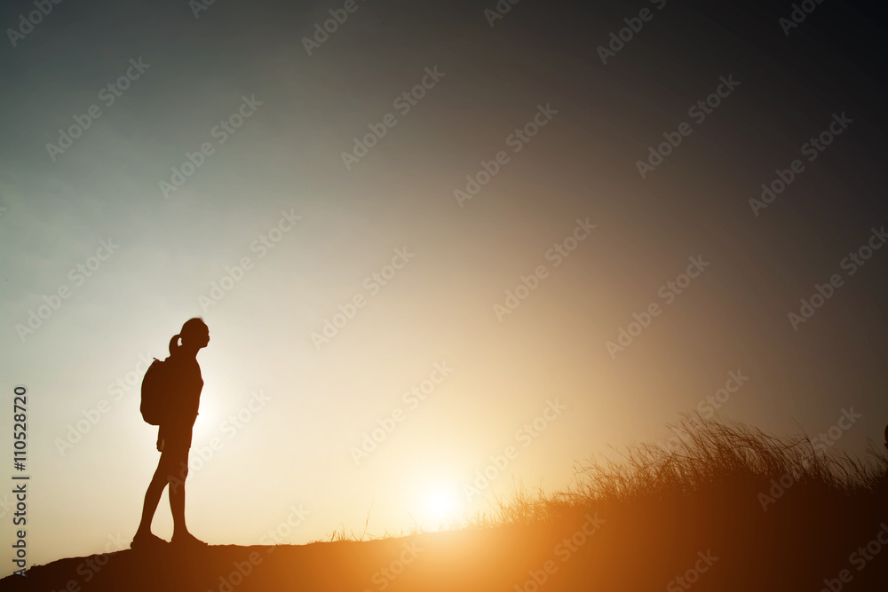 Silhouette of woman backpacking with sunset.