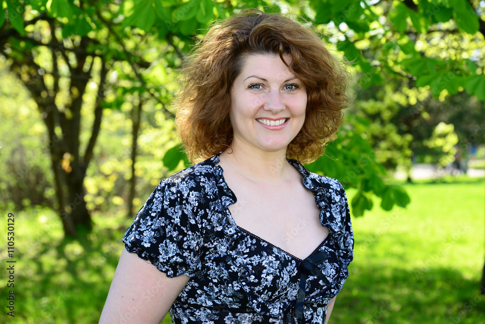 Portrait of beautiful cheerful woman in the summer park