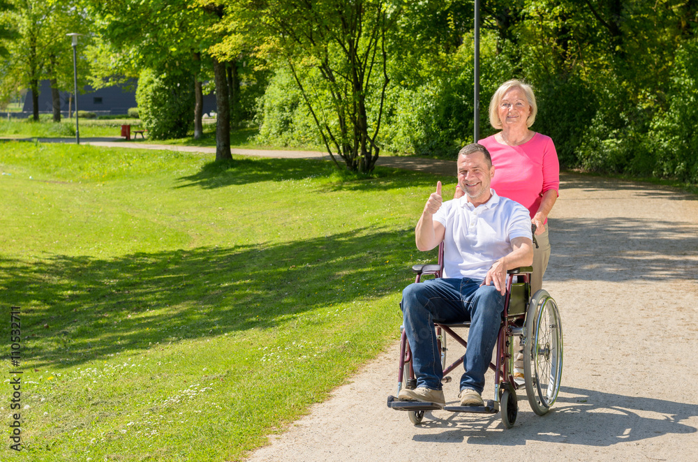 Elderly woman in pink blouse pushes wheel chair Elderly woman in pink blouse pushes wheel chair