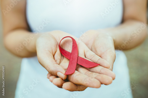Slika na platnu red aids ribbon in hand.