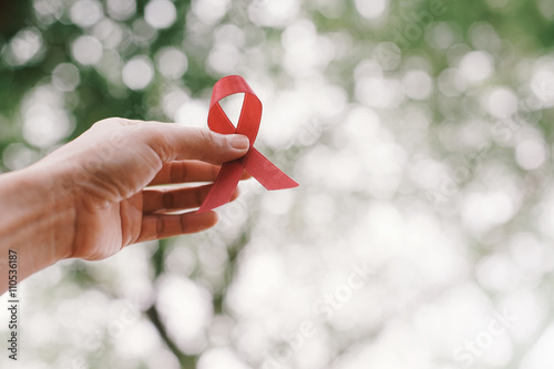 Slika na platnu red aids ribbon in hand.
