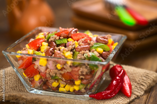 Chili con carne Salat aus Hackfleisch, rote Bohnen, Paprika, Tomate, Mais und Zwiebeln in Glasschüssel serviert (Selektiver Fokus, Fokus in die Mitte des Salats)