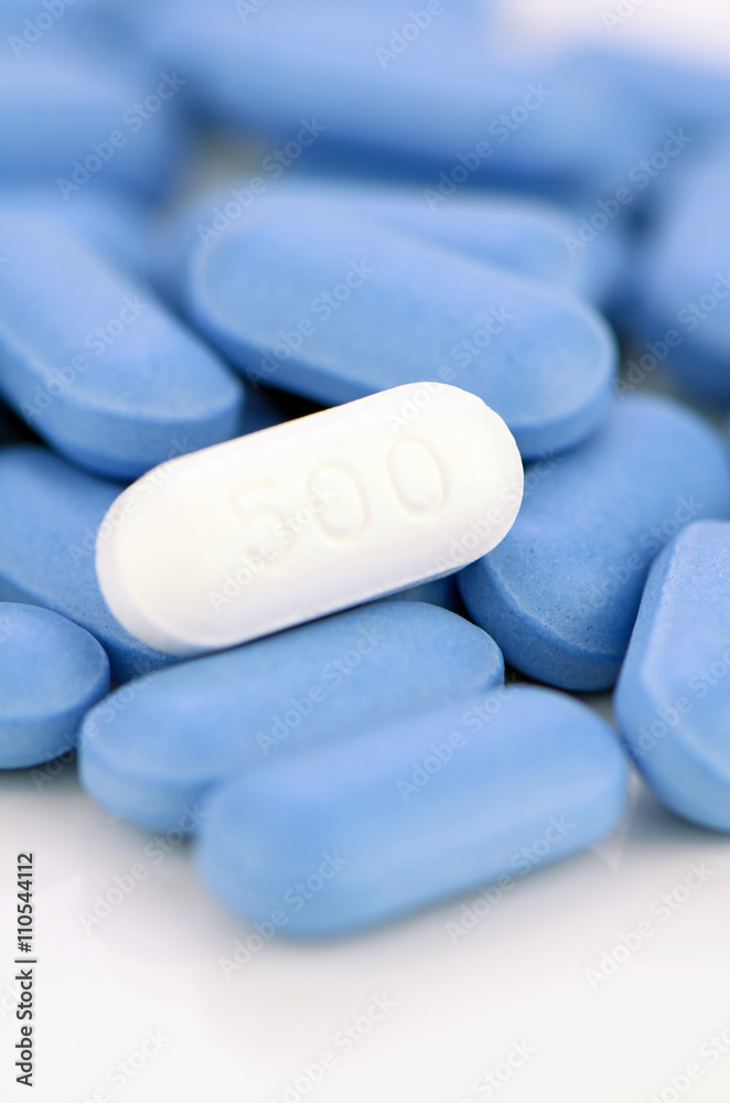 White caplet on blue caplets background. White caplet on blue caplets background.