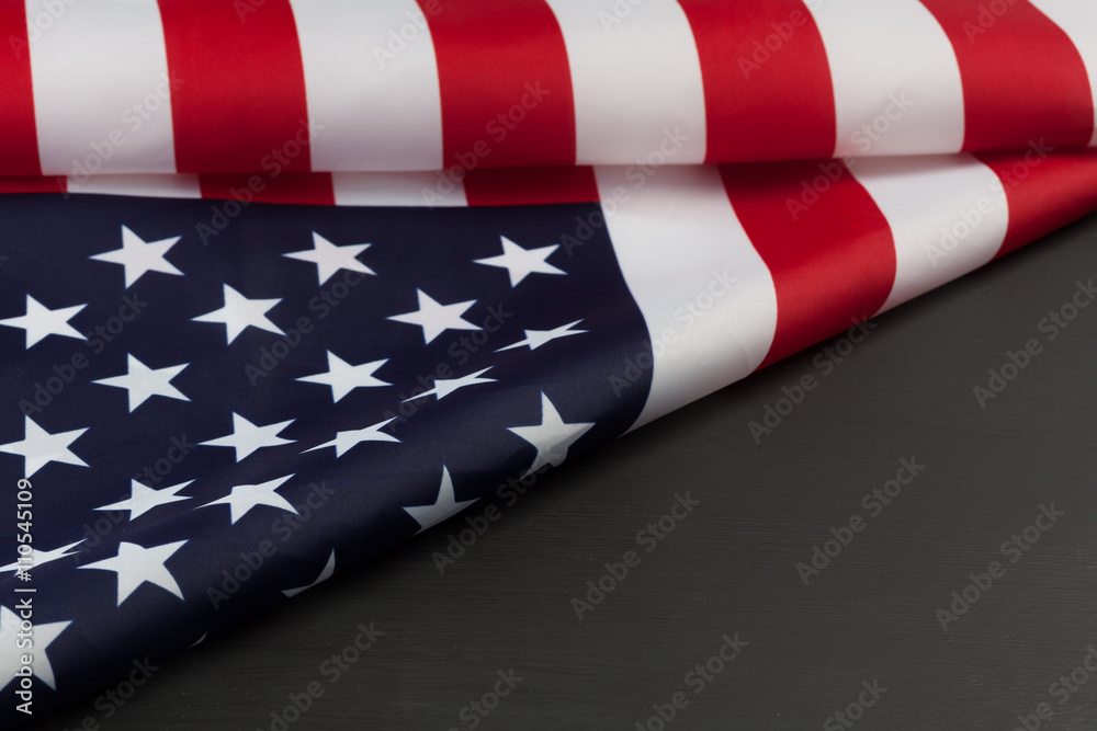 Fototapeta premium Folded American flag on black chalkboard with diagonal copy space