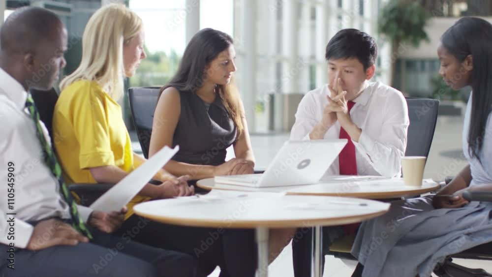 Businessman giving presentation to colleagues in modern glass office Businessman giving presentation to colleagues in modern glass office