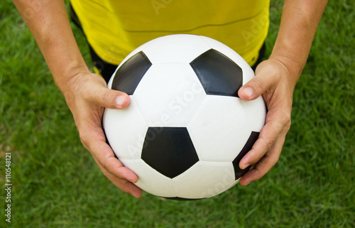 Soccer player holding a football. © sirikornt