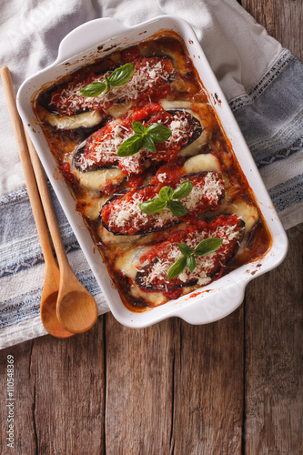 Italian eggplant baked with mozzarella in tomato sauce in baking dish. vertical top view 