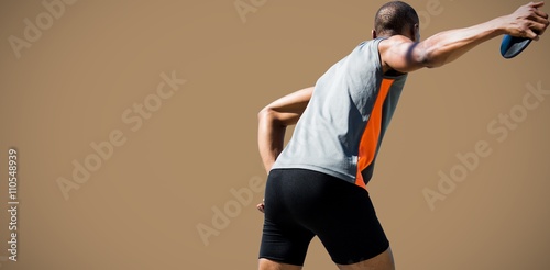 Tableau sur toile Composite image of rear view of sportsman practising discus thro