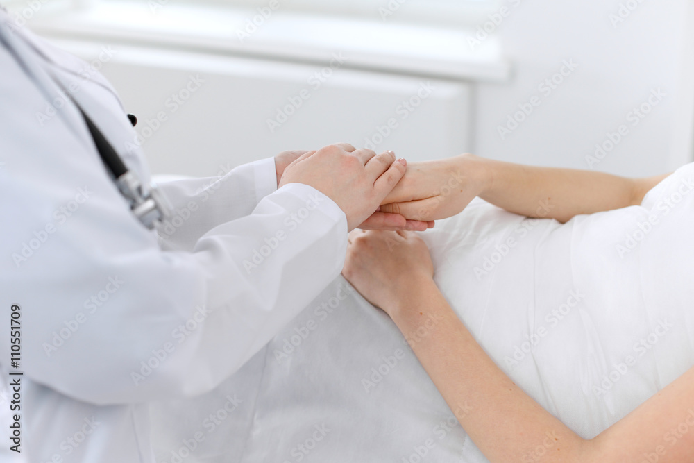 Hand of doctor reassuring her female patient Hand of doctor reassuring her female patient
