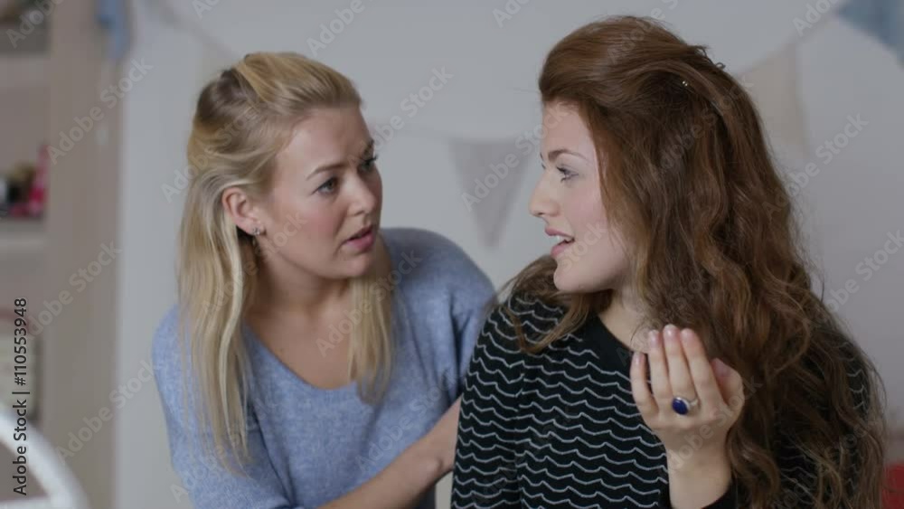 Teenage girls in bedroom, one girl tries to comfort her sad friend Teenage girls in bedroom, one girl tries to comfort her sad friend
