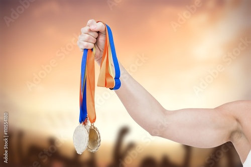 Composite image of female athlete holding medals