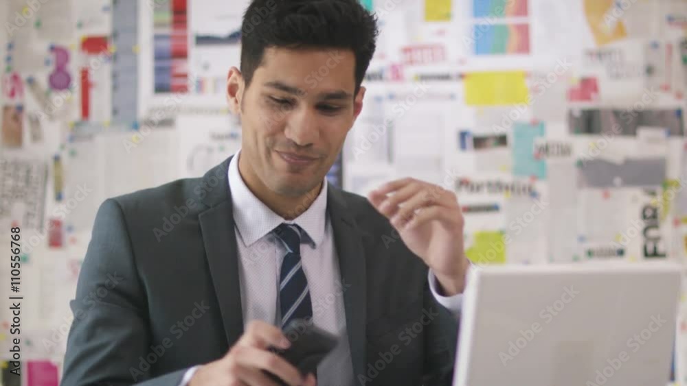 Businessman in office working on laptop computer & making phone call. Businessman in office working on laptop computer & making phone call.