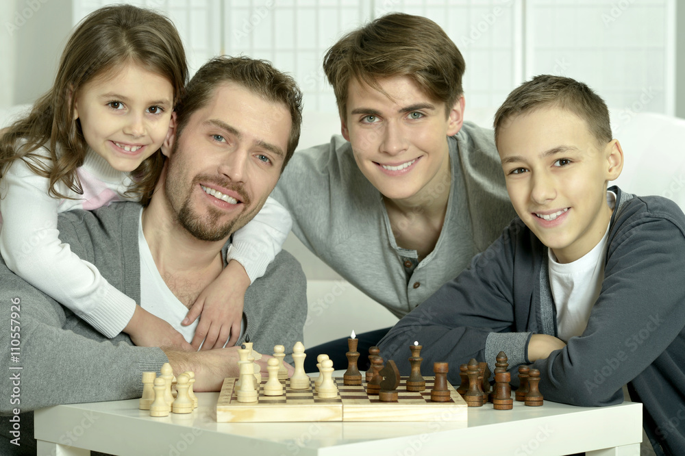 Family playing chess at home